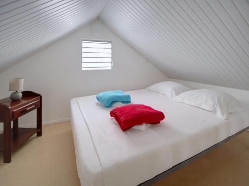 a white bed with two pillows on it in a room at Résidence Ti'Kéol - Appartements avec terrasse 2 à 4 personnes, piscine in Sainte-Anne