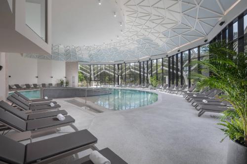 a swimming pool in a building with lounge chairs at Luxury Glamping Beach Villas Porto Bus in Bale