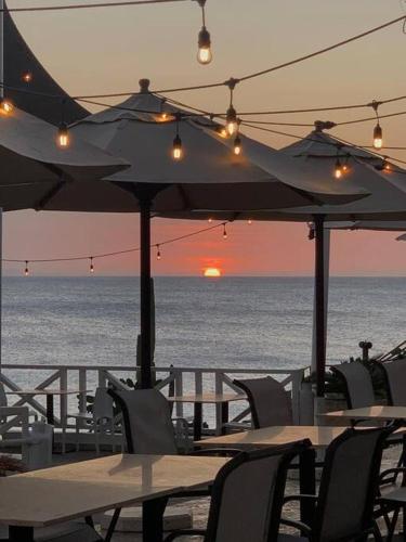 an outdoor restaurant with tables and chairs and the ocean at Bungalow #12 at Waterfront Playa Alicia in Sosúa