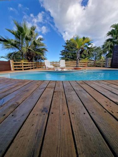 a wooden deck in front of a swimming pool at Villa Moadip in Saint-Leu