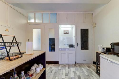 une cuisine avec des placards blancs et une porte blanche dans l'établissement L’Antiquaire ~ Centre-Ville ~ Arrivée Autonome, à Dijon