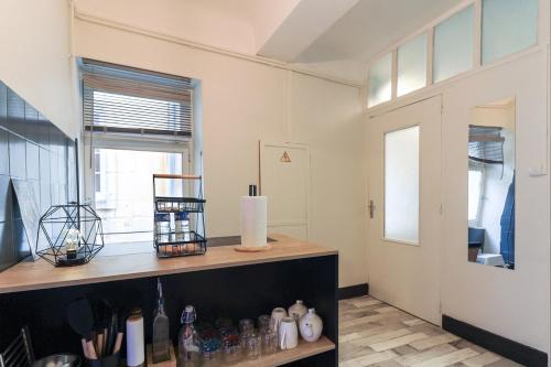 une pièce avec un comptoir avec des bouteilles et une fenêtre dans l'établissement L’Antiquaire ~ Centre-Ville ~ Arrivée Autonome, à Dijon