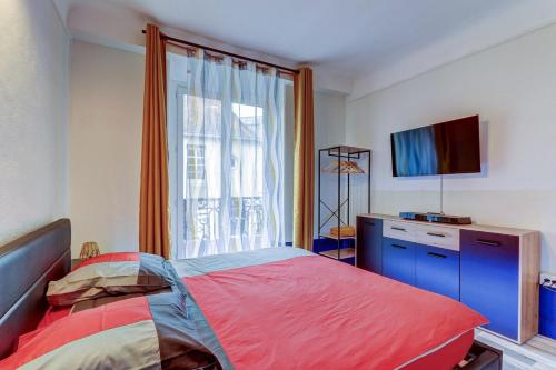 une chambre avec un lit et une télévision à écran plat dans l'établissement L’Antiquaire ~ Centre-Ville ~ Arrivée Autonome, à Dijon