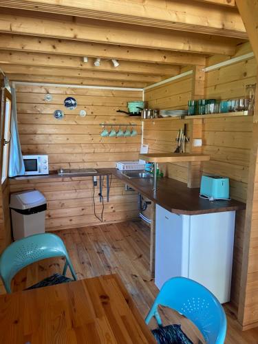 a kitchen with wooden walls and a table and chairs at Pokoje i domki letniskowe BROS in Dziwnów
