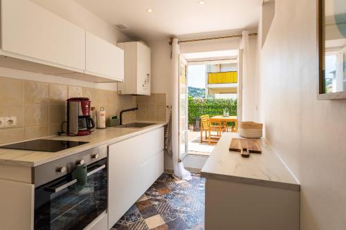 une cuisine avec des armoires blanches et un comptoir dans l'établissement maison de ville La Fontaine BAu4, au Cannet