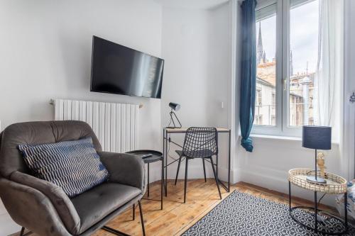 Il comprend un salon avec une chaise et une télévision à écran plat. dans l'établissement Le Mauna Loa ~ Centre-ville ~ Climatisation, à Clermont-Ferrand