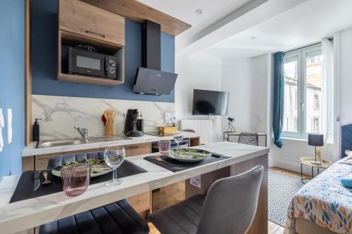 une cuisine avec une table et des assiettes de nourriture dans l'établissement Le Mauna Loa ~ Centre-ville ~ Climatisation, à Clermont-Ferrand