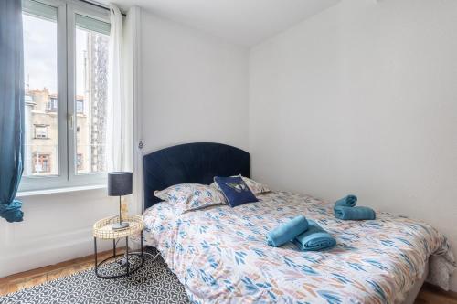 une chambre avec un lit avec des oreillers bleus dessus dans l'établissement Le Mauna Loa ~ Centre-ville ~ Climatisation, à Clermont-Ferrand