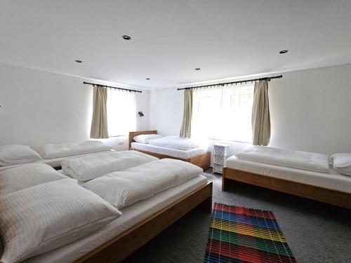 a bedroom with four beds and a window at Chata Partizánka in Liptovský Ján