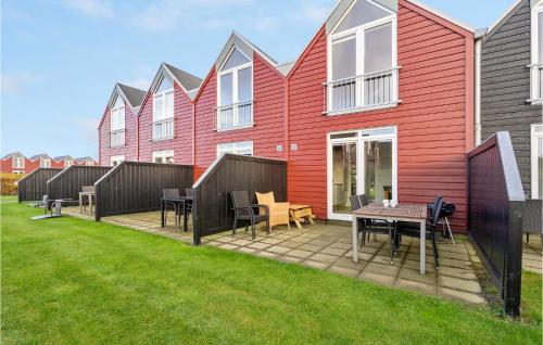 eine Terrasse mit Tischen und Stühlen vor einer Reihe von Häusern in der Unterkunft Stunning Home In Nørre Nebel With Wifi in Nørre Nebel