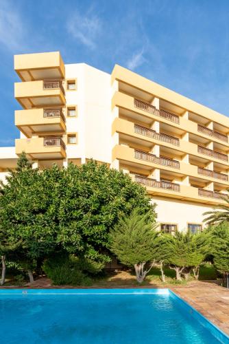a hotel with a swimming pool in front of a building at Parador de Melilla in Melilla