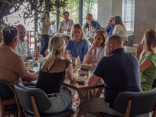 a group of people sitting at a table in a restaurant at Sea Star Budva in Budva