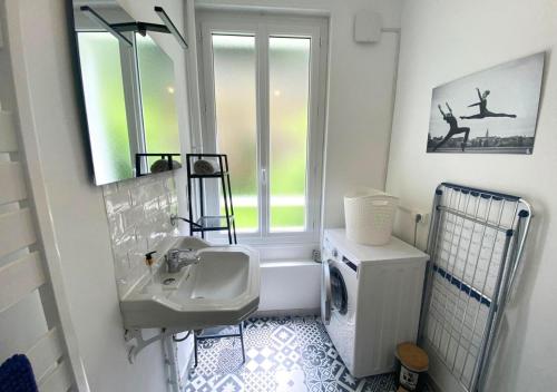 une salle de bain blanche avec un lavabo et une fenêtre dans l'établissement Le Grand Cerf - Poitiers - Gare, à Poitiers