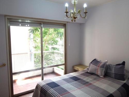 a bedroom with a bed with a view of a balcony at Apartamento in Rosario
