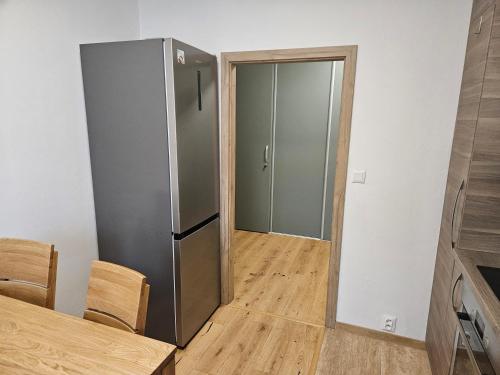 a kitchen with a stainless steel refrigerator and a table at Apartmány Skalica in Skalica
