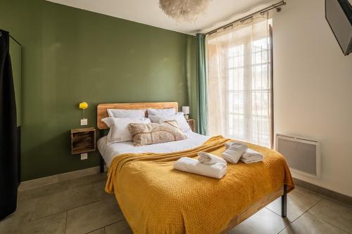 - une chambre verte avec un lit et des serviettes dans l'établissement OIQIA • Eden, à Carcassonne