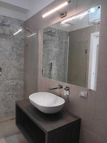 a bathroom with a white sink and a mirror at Villa Agapanto in Paestum