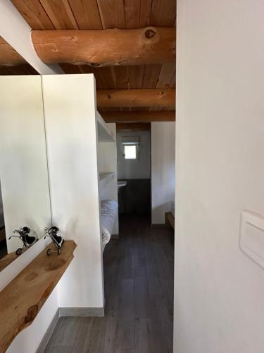 Cette chambre est dotée de murs blancs et d'un plafond en bois. dans l'établissement natur o lodge piscine, à Gagnières