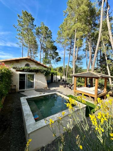 une cour arrière avec une piscine et une maison dans l'établissement natur o lodge piscine, à Gagnières