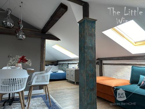 a bedroom with a bed and a table and chairs at Пространства за гости Синият час - апартамент Little Wing in Ruse