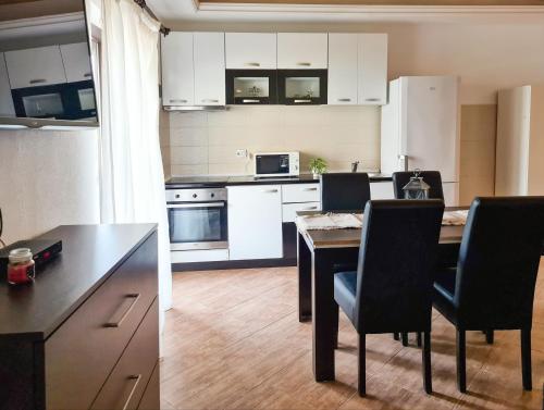 a kitchen with a dining table and a kitchen with white cabinets at Step to Kotor bay St-oliv in Kotor