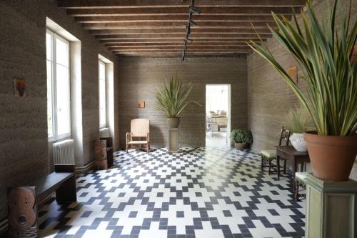 een kamer met potplanten op de vloer van een gebouw bij L'Auberge 91530 in Le Val-Saint-Germain