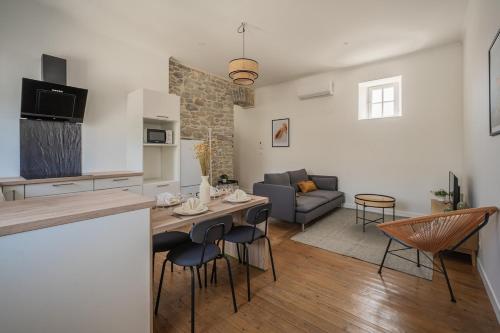 une cuisine et un salon avec une table et des chaises dans l'établissement Le Sicilien ~ Climatisation ~ Centre-ville, à Carcassonne
