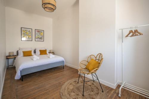 Un dormitorio con una cama y una silla dentro. en Le Sicilien ~ Climatisation ~ Centre-ville, en Carcassone