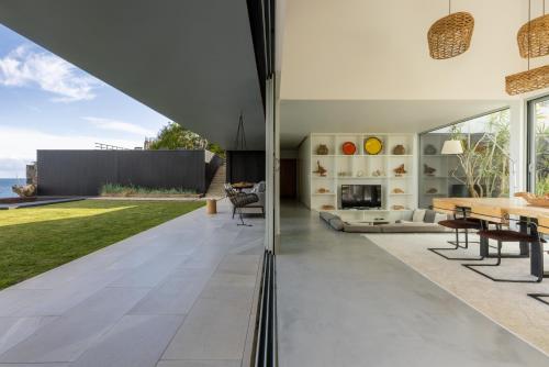 an open living room with a fireplace and a table at White Exclusive Suites & Villas in Lagoa