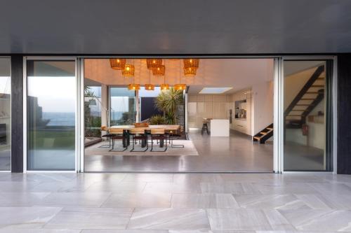 a dining room with glass doors and a table at White Exclusive Suites & Villas in Lagoa