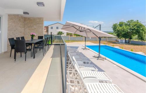 a patio with a table and chairs and a pool at 4 Bedroom Nice Home In Slivnica Donja in Knežević