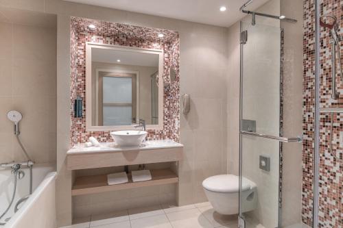 a bathroom with a toilet and a sink and a shower at Hilton Evian Les Bains in Évian-les-Bains