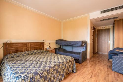 a bedroom with a bed and a chair in it at Hotel Porta Del Sole in Soiano del Lago