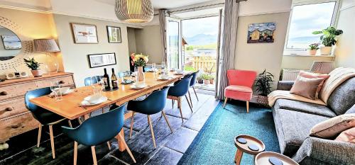 a dining room with a table and chairs and a couch at Harbour & Mountain Views, Porthmadog House, Sleeps 9, 4 Bedrooms, Two and Half Bathrooms in Porthmadog