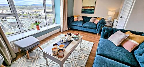a living room with a couch and a table at Harbour & Mountain Views, Porthmadog House, Sleeps 9, 4 Bedrooms, Two and Half Bathrooms in Porthmadog