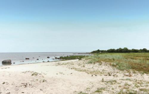 a sandy beach with rocks in the water at Holiday Home N, Honungstorp Löttorp in Löttorp