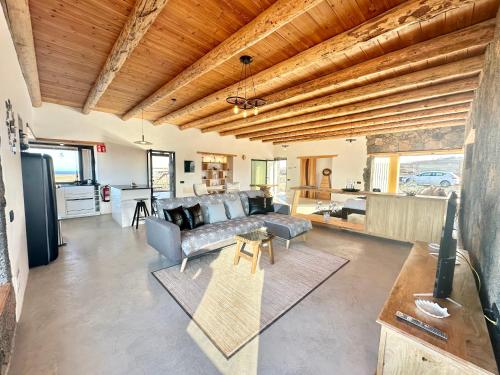 a living room with a couch and a table at Casita Tahona con vistas de infarto al mar y volcanes con absoluta privacidad in Parque Holandes