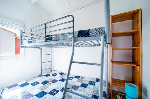 un lit superposé dans une pièce avec une échelle et un lit superposé gmaxwell gmaxwell gmaxwell dans l'établissement Miroir d'Azur - Studio vue sur étang, au Barcarès