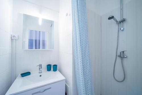 une salle de bain blanche avec un lavabo et une douche dans l'établissement Miroir d'Azur - Studio vue sur étang, au Barcarès