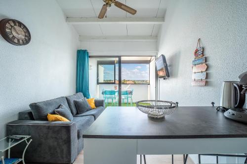 un salon avec un canapé et une table dans l'établissement Miroir d'Azur - Studio vue sur étang, au Barcarès