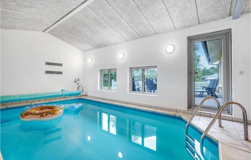 a swimming pool with blue water in a house at Holiday Home Lærkevænget Ebeltoft V in Ebeltoft
