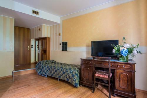 a room with a desk with a tv on it at Hotel Porta Del Sole in Soiano del Lago