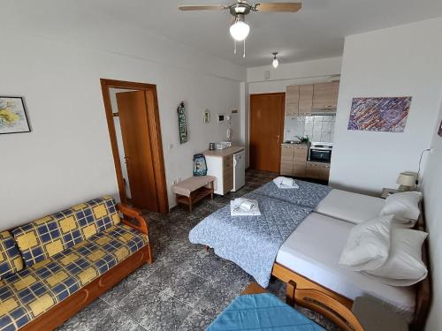a bedroom with a bed and a couch in it at Peristerianos apartments in Nea Skioni