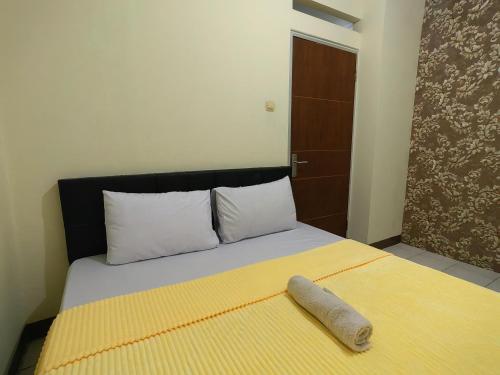 a bedroom with a bed with a pillow on it at Cibubur Village By Arsakha Property Management in Cibubur