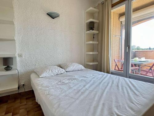 une chambre avec un lit et un balcon avec une table dans l'établissement Appartement 2 pièces avec parking privé à 300m de la plage - Argelès-sur-Mer - FR-1-225-62, à Argelès-sur-Mer