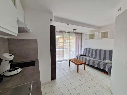 un salon avec un canapé et une table dans l'établissement Appartement en bord de mer avec piscine, terrasse et parking privé - FR-1-387-67, à Marseillan