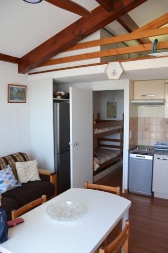 une cuisine et un salon avec une table et un canapé dans l'établissement Appartement Capbreton, à Capbreton