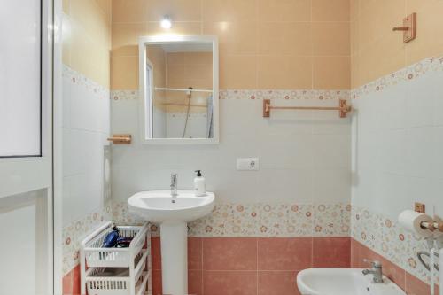 un baño con lavabo y espejo en Piso Ureba, bajo, en Conil de la Frontera
