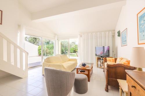 un salon avec un canapé et une télévision dans l'établissement Palmeria - Maison climatisée accès direct plage, à Canale-di-Verde