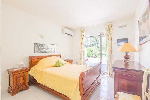 une chambre avec un lit avec un couvre-lit jaune dans l'établissement Palmeria - Maison climatisée accès direct plage, à Canale-di-Verde